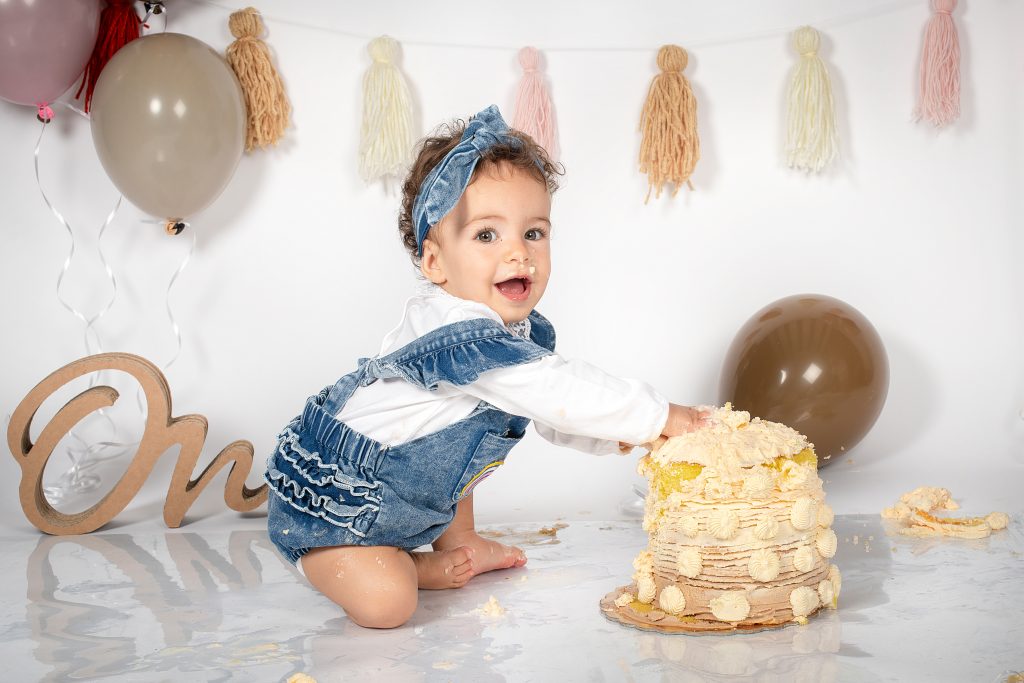 bimba mangia la torta di compleanno durante servizio fotografico