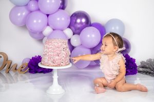 bimba mangia la torta di compleanno durante servizio fotografico